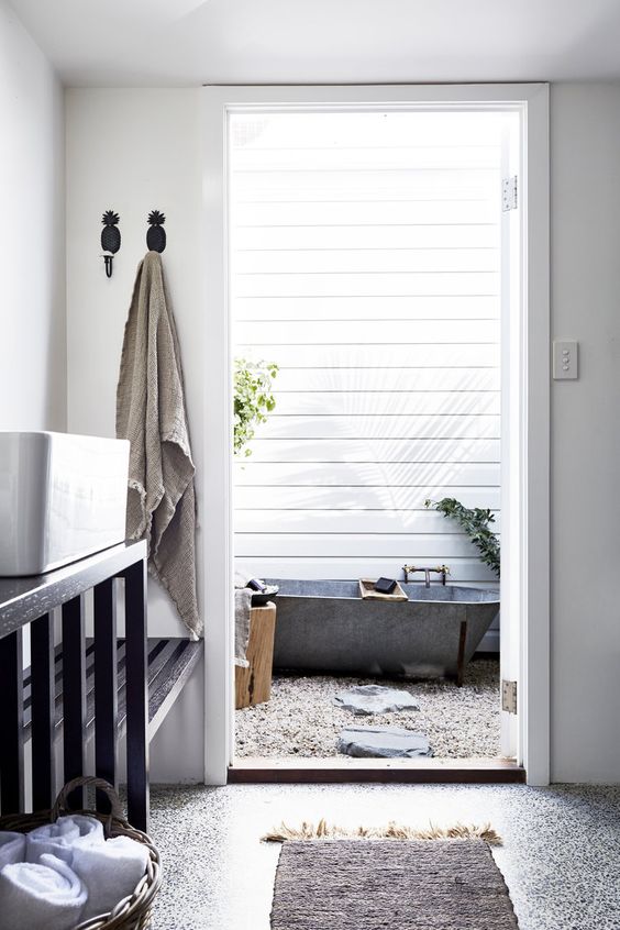 the house continued in a private courtyard with a stone bathtub, pebbles and greenery planted