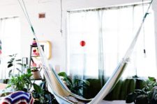 13 this indoor space feels like outdoors thanks to potted greenery, colorful textiles and a striped hammock