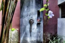 14 a tropical-inspired outdoor shower with tropical plants and flowers and a concrete and plaster shower space