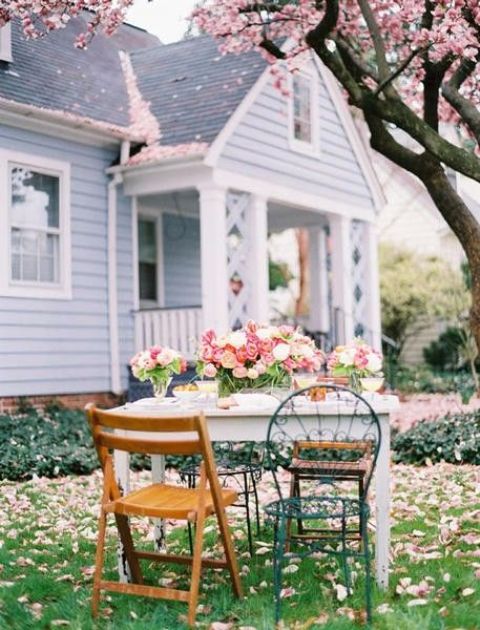 a simple white table is spruced up with colorful chairs and wooden foldable ones