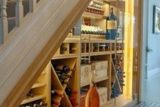 16 a wine cellar with glass doors and wooden storage units with additional lights to easily find a bottle