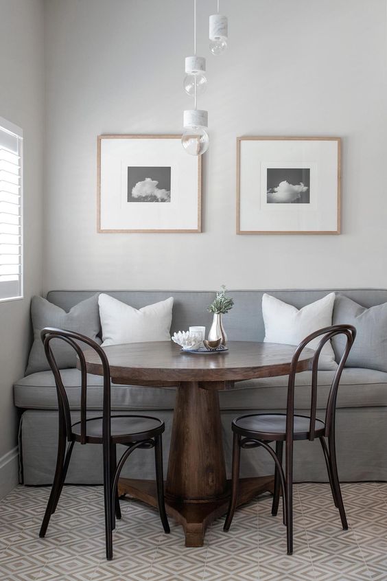 a simple grey banquette seating with a wooden table and chairs for an eclectic space