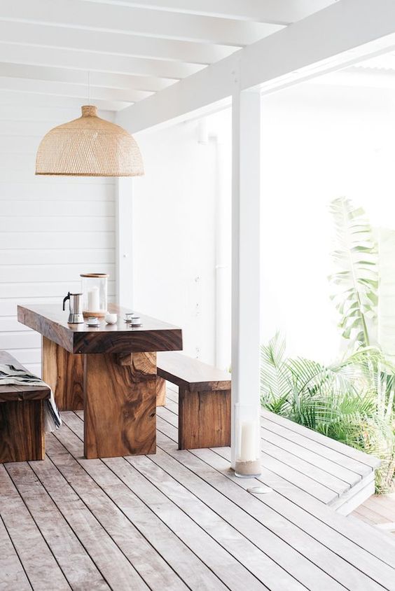 a minimalist space with a wooden dining set and a wicker lampshade for a laconic and welcoming look