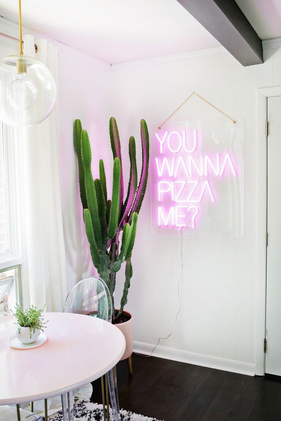 make your dining space fun and whimsical with a large cactus in a planter and a neon light sign for a wow look