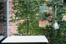 24 a vintage industrial outdoor space with a brick wall covered with winves and a green bathtub