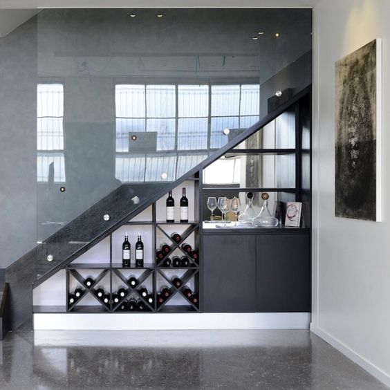 a wine storage space and a bar space in one accommodated under the stairs