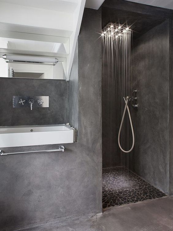 a full grey concrete bathroom with a mosaic floor in the shower, a very durable solution