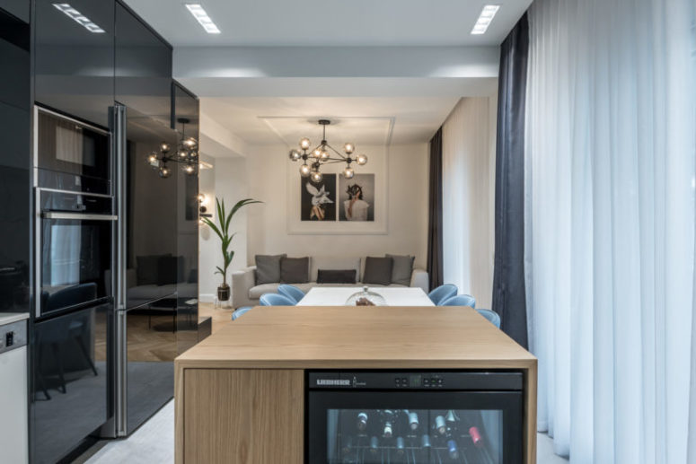 The kitchen, living and dining rooms became one open layout separated only with a large kitchen island of wood and marble The kitchen, living and dining rooms became one open layout separated only with a large kitchen island of wood and marble
