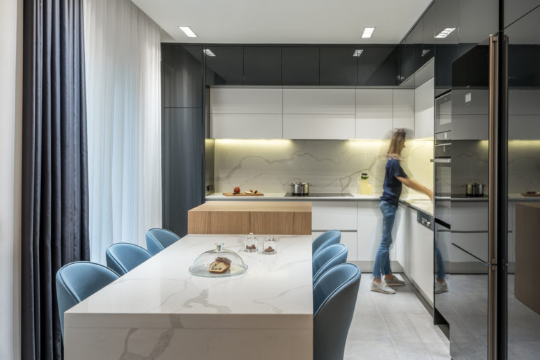marble backsplash design The kitchen is black and white, with a white marble backsplash and lights and a cooking surface of wood