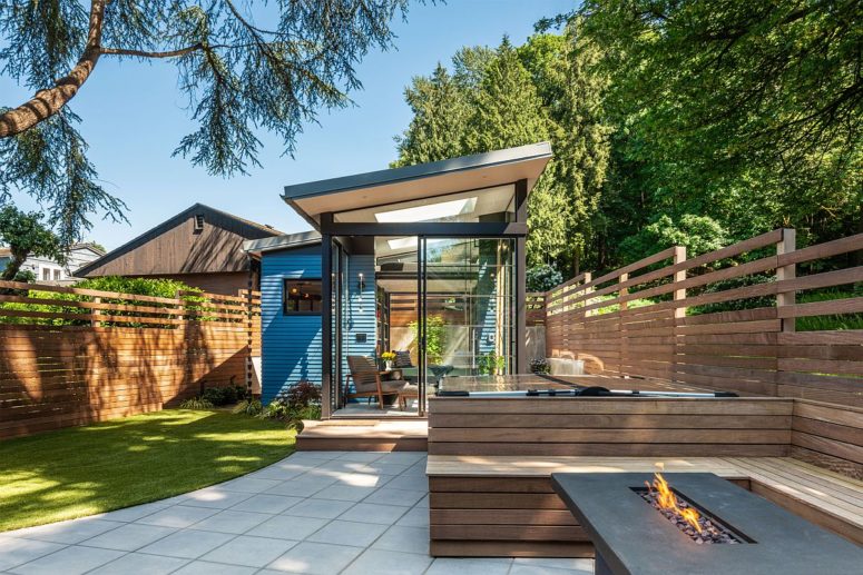 The shed is clad with glass and wood and is opened to the backyard