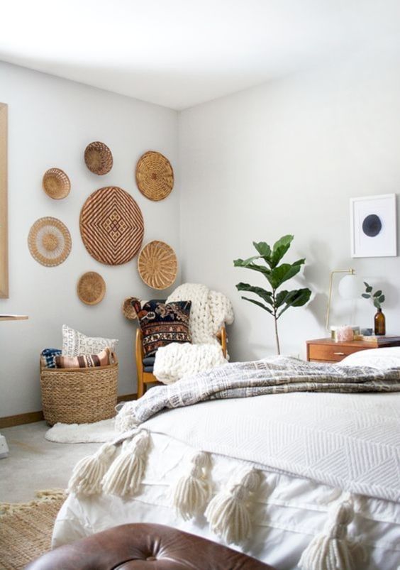 some wicker baskets on the wall, a basket for storage, tassels and chunky knit for a boho bedroom