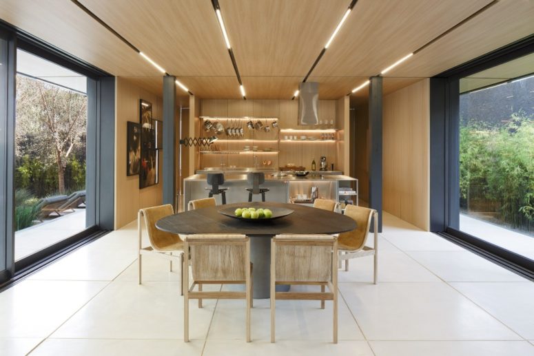 kitchen opened to outdoors The dining space is united with the kitchen, there's much wood and metal pillars, the space can be opened to outdoors on two sides