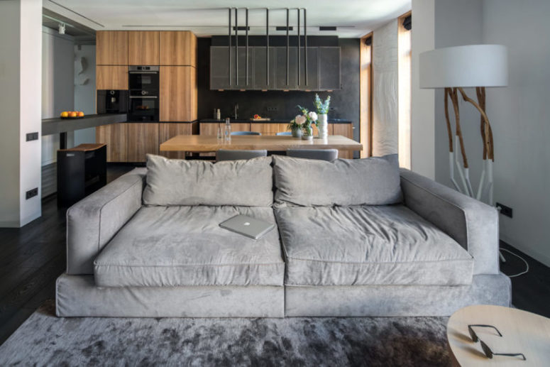 The large sofa serves a natural space divider, which separates but not too much