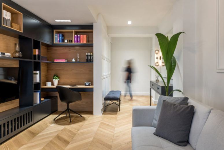 The living room features rather dramatic contrasts between black and wood and a comfy working space built-in