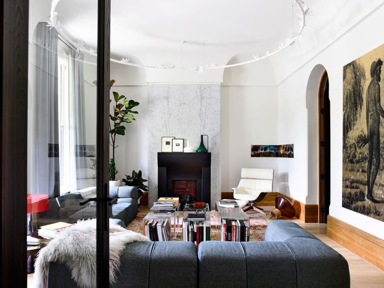 The living room shows off gorgeous art, stylish furniture, a unique hanging piece and a stylish faux fireplace The living room shows off gorgeous art, stylish furniture, a unique hanging piece and a stylish faux fireplace