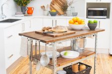 04 a mobile industrial kitchen island of metal and wood with two shelves and hooks and holders for an edgy touch
