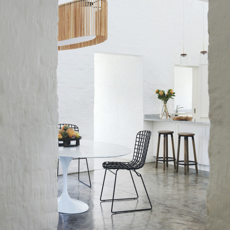 There's a dining zone next to the kitchen, with a modern table and wire chairs plus a statement lamp over them There's a dining zone next to the kitchen, with a modern table and wire chairs plus a statement lamp over them