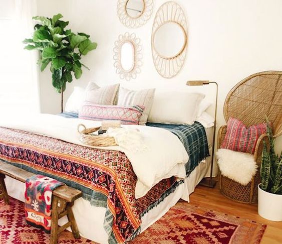 some wicker touches like a chair and framed mirrors plus printed textiles create a boho look easily