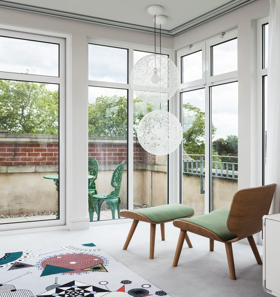 The bold printed rug and a comfy lounge chair with a footrest add interest to the relaxing and comforting space