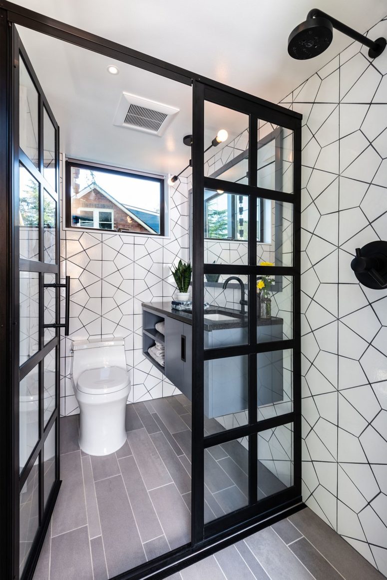 There's a small mudroom with white tiles, a floating vanity and small windows