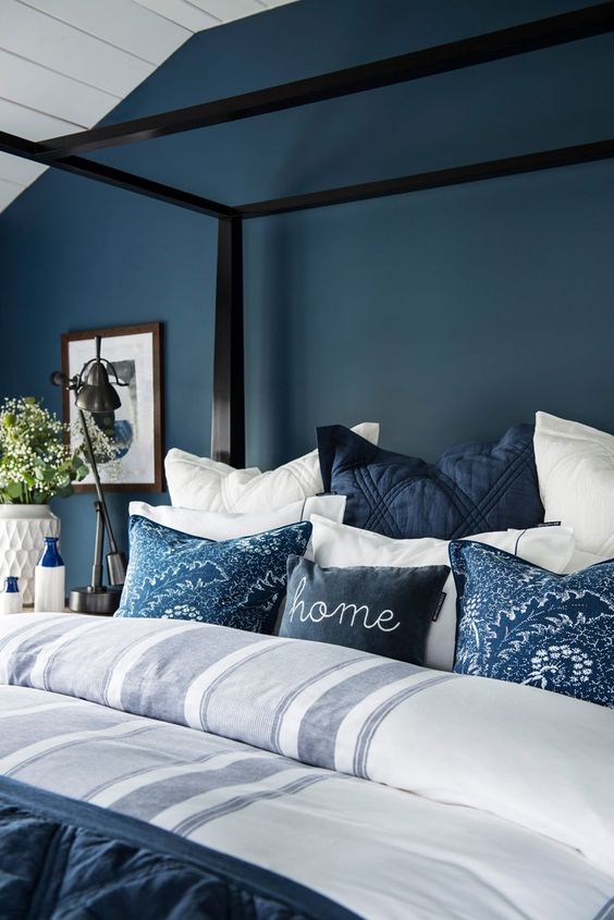 a navy statement wall plus naxy pillows and a blanket contrast whites and make the space relaxing