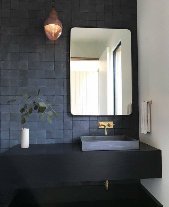 gorgeous matte midnight blue tiles on the wall and a matching sink create a trendy moody look