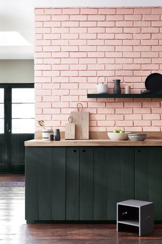 a pink quartz brick wall and black wooden plank cabinets make up a stylish look with a lot of texture