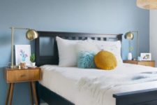 07 a slate blue accent wall and mustard touches add color to the mid-century modern bedroom