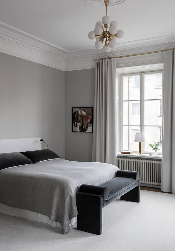 a light grey bedroom with black touches that add depth and drama to the space