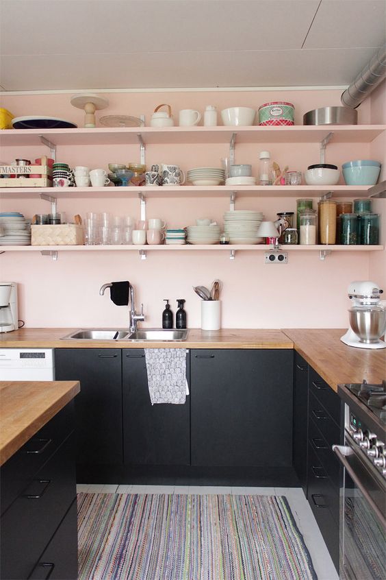 blush walls and shelves contrast the black cabinets and create a chic and stylish color combo