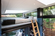 09 A ladder invites to a small sleeping space up, a bed with a skylight and windows on each side