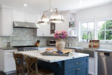 11 a beautiful white kitchen with a navy kitchen island and a marble countertop for a chic touch