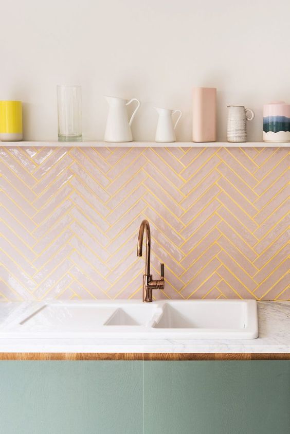 a pink chevron clad tile backsplash with neon yellow grout adds a bold touch to the kitchen