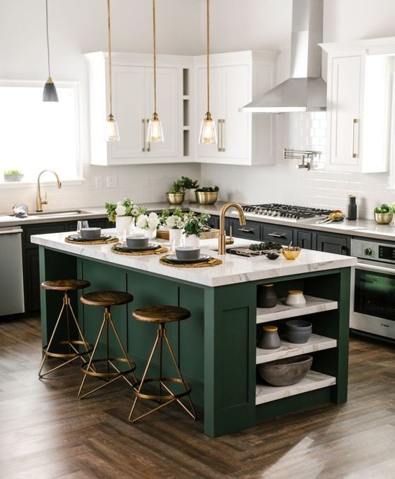 a black and white kitchen with a dark green kitchen island that adds color to the space