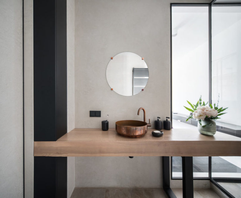 The chic wooden vanity is spruce dup with a copper sink and faucet