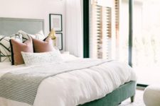 13 a green upholstered bed and matching framing of the windows and doors for a bold look