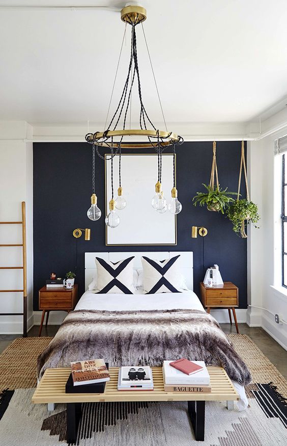 a navy statement wall and gilded touches create a very chic and bold space with a boho feel