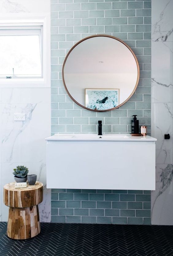 an aqua blue tile accent on the wall highlights the mirror and the floating vanity