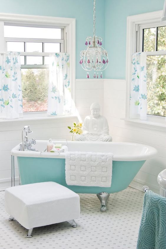a light blue wall and a turquoise bathtub on silver legs for a chic and eye-catchy look in your bathroom
