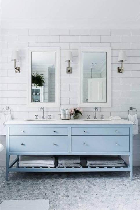 a powder blue double vanity with silver touches creates a romantic coastal feel in the bathroom