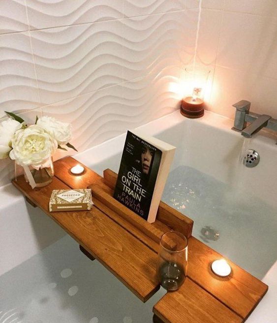 a stylish bath caddy with a glass holder and a book or gadget holder