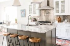 19 a white kitchen with a grey kitchen island, a stone countertop and a metallic tile backsplash add interest