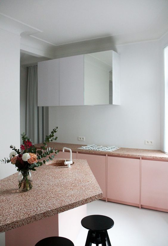 blush kitchen cabinets with terrazzo countertops and white upper cabinets for a trendy look