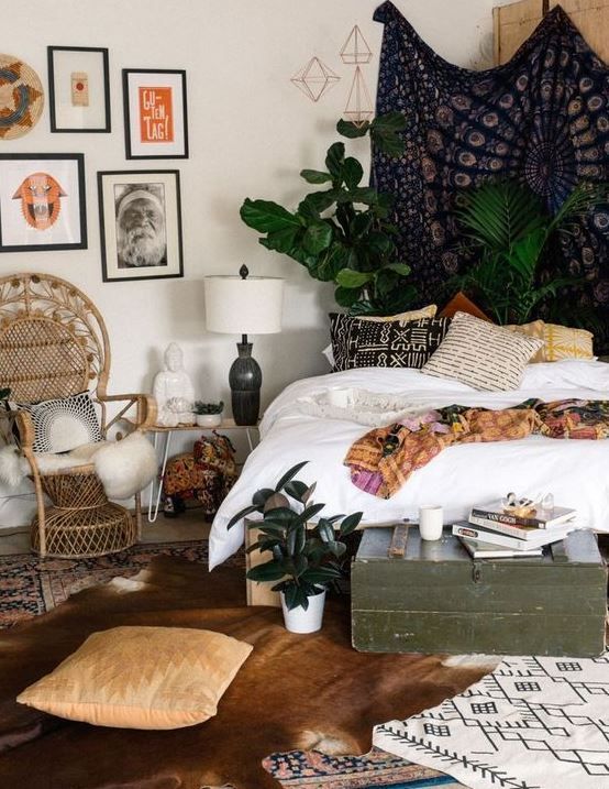 lots of boho rugs, boho pillows, a wicker chair and a green chest for storage