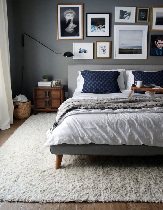 a grey bedroom with a colorful gallery wall over the headboard that adds color and interest