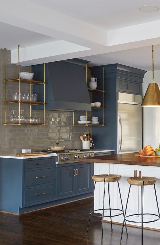 navy vintage-inspired cabinets are enlivened with a white kitchen island with a wooden countertop for a wow look