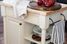 23 a vintage rustic kitchen island in white with much storage space and a wooden countertop