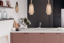 23 dusty pink cabinets, black and white walls and exquisite pendant lamps create a sophisitcated look