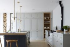 24 vintage-inspired grey cabinets and a navy kitchen island in the same style with a wooden countertop for a chic look
