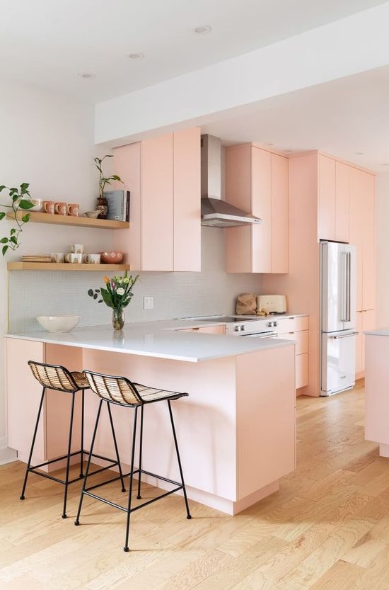 a lovely peachy pink flat panel kitchen with white granite countertops, tall woven stools and open shelving is amazing